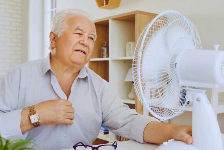Anziano con ventilatore acceso per il caldo