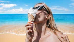 Giovane donna al mare con cono gelato