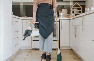 donna con prodotti per pulizia casa