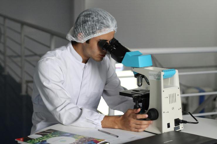 scienziato al microscopio
