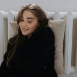 donna appoggiata al termosifone